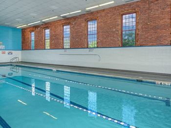A swimming pool with a brick wall and windows